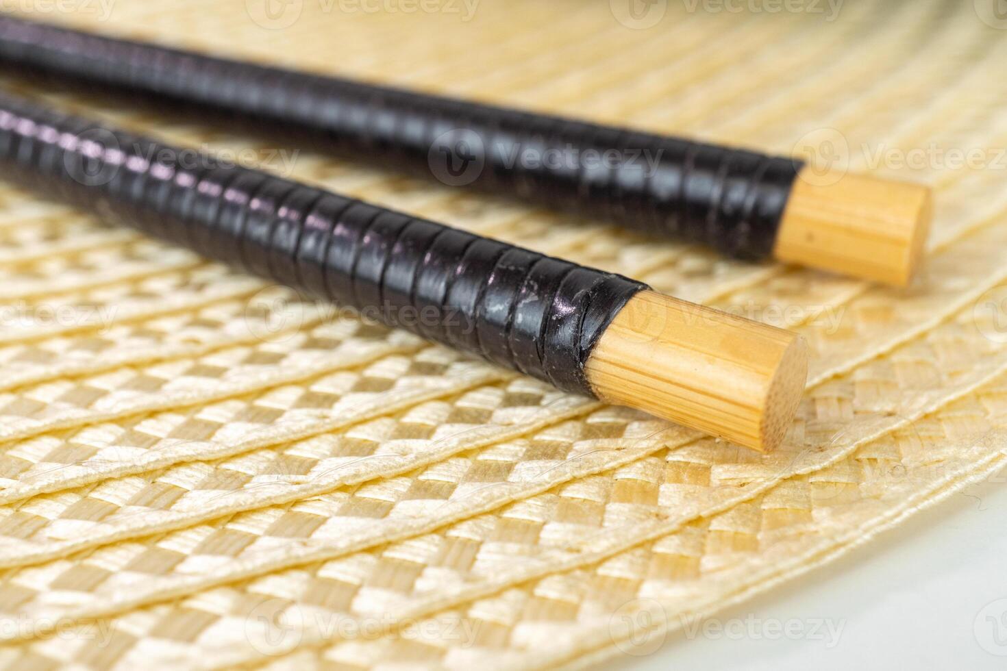 Detailed view of traditional bamboo chopsticks on woven mat surface photo