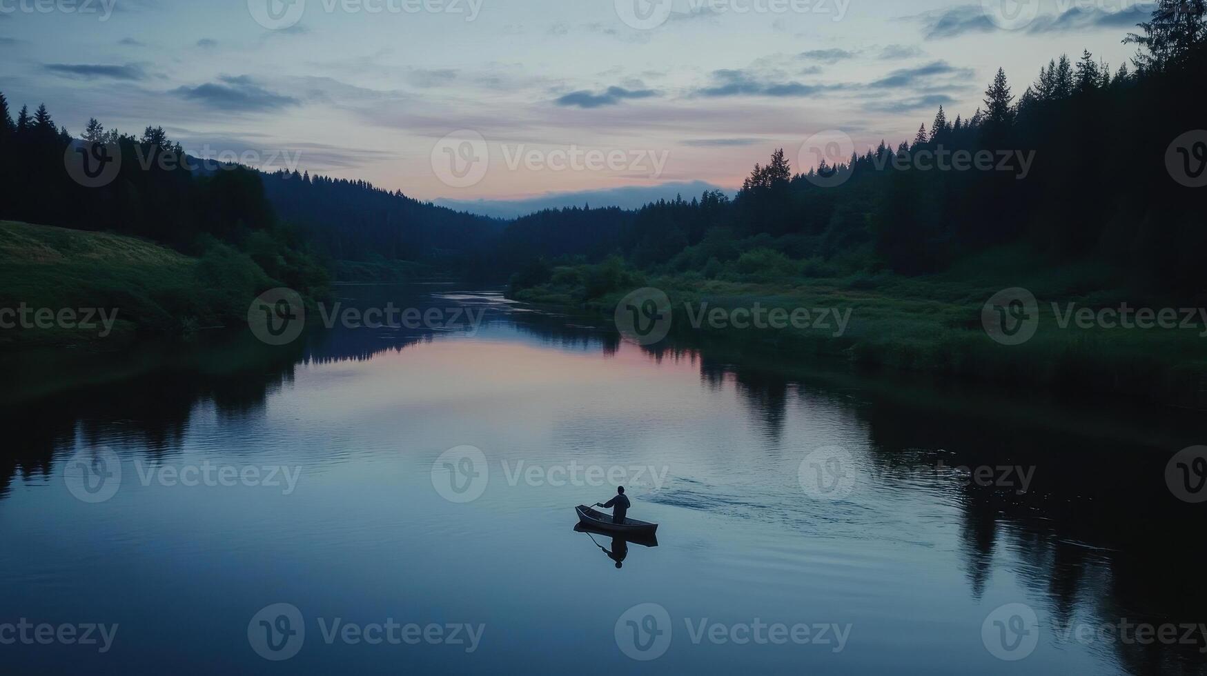 A serene sunset over a calm river, with a lone canoeist gliding through the water, surrounded by lush forests and tranquil reflections. photo