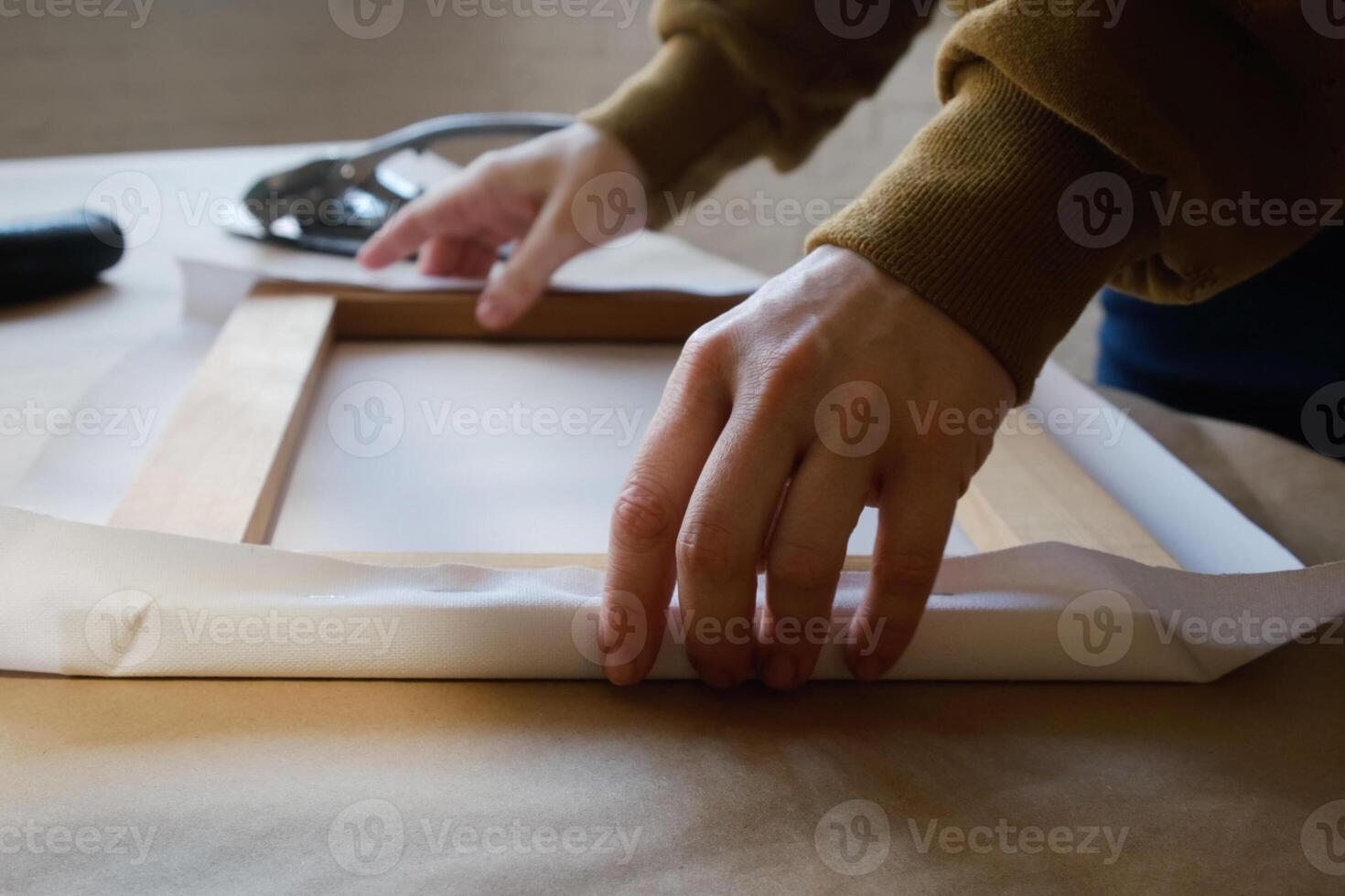Stretching canvas on stretcher bars in workshop. Gallery wrap. Print on canvas. photo