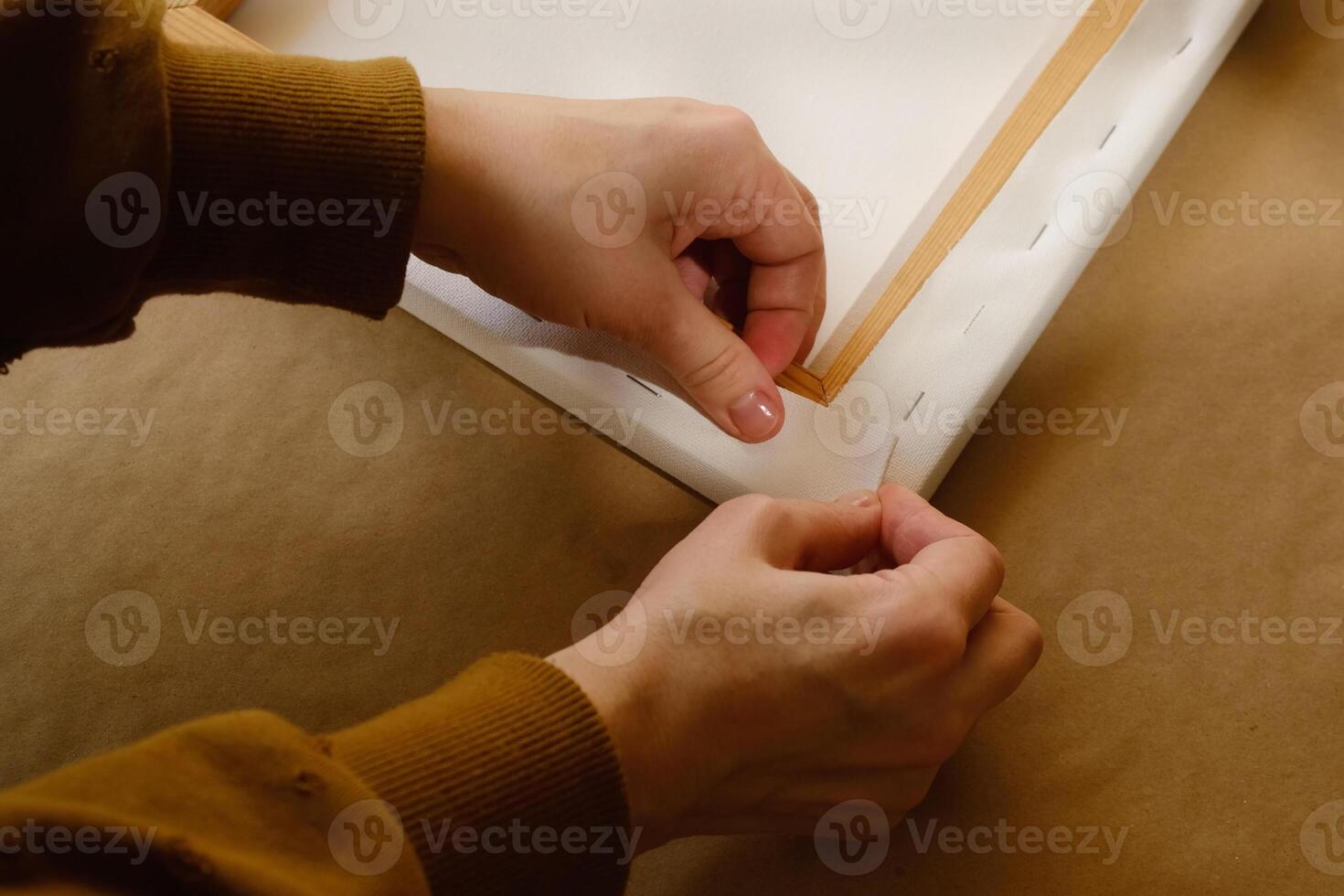 Hands stretching canvas on wooden stretcher. Gallery wrap. Print on canvas. photo