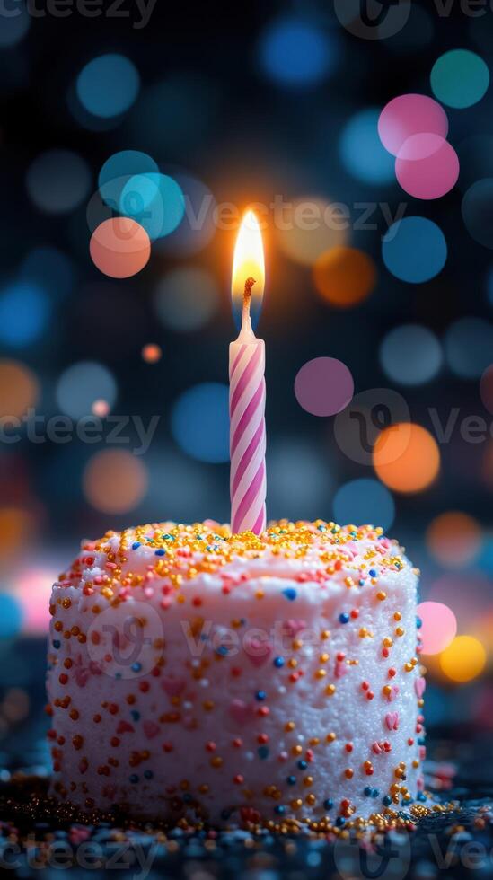 Celebrate special moments with a beautifully lit birthday cake adorned with colorful sprinkles and a single candle photo