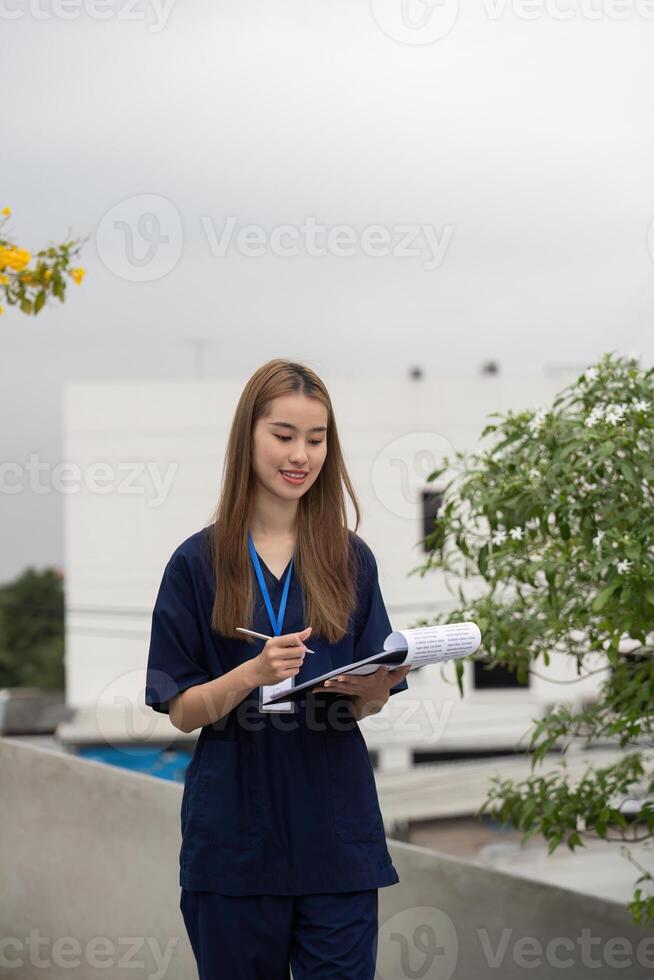Female doctor enjoying a break, writing notes and sipping coffee in a serene outdoor setting. photo