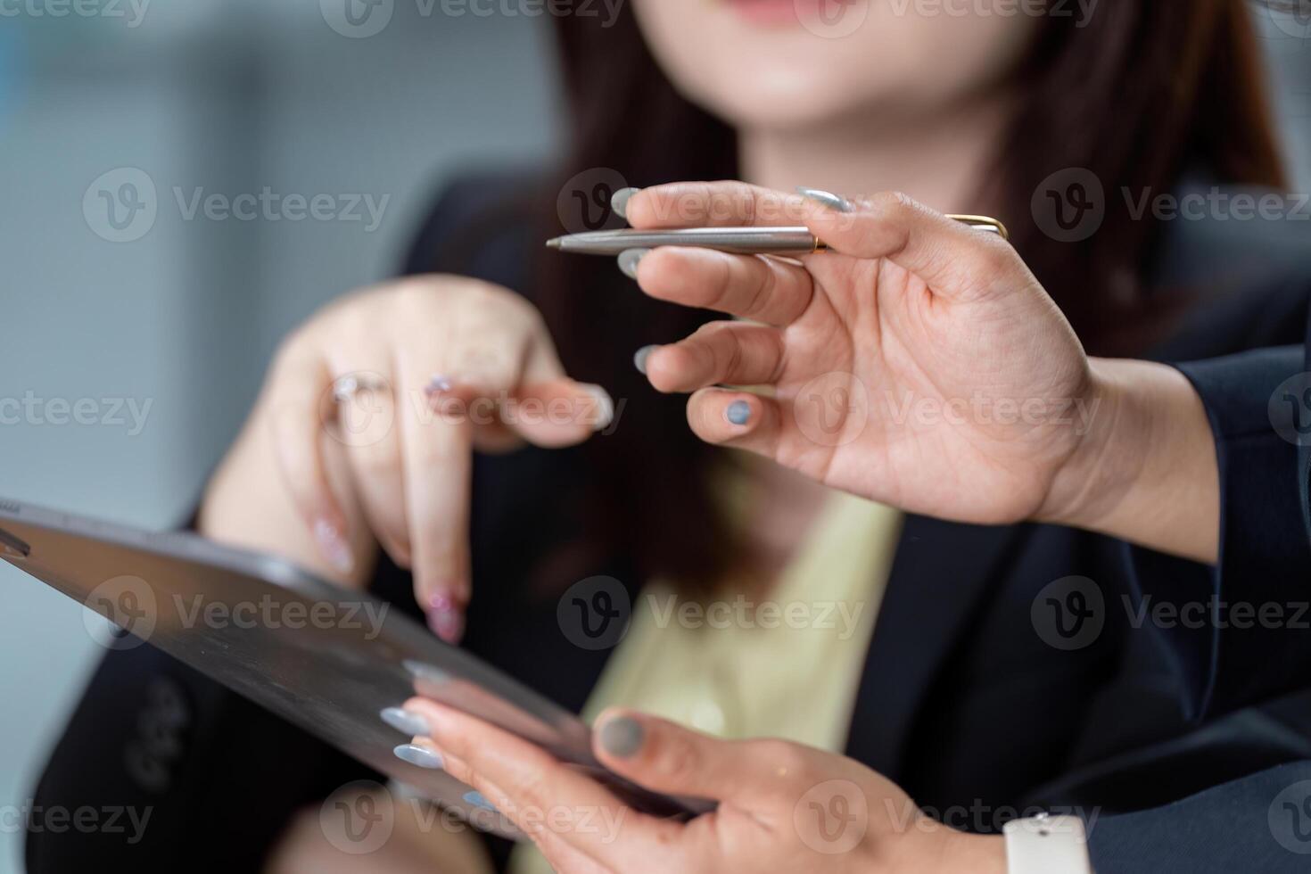 Hands of business professionals collaborating on financial analysis with a tablet in a modern office. photo