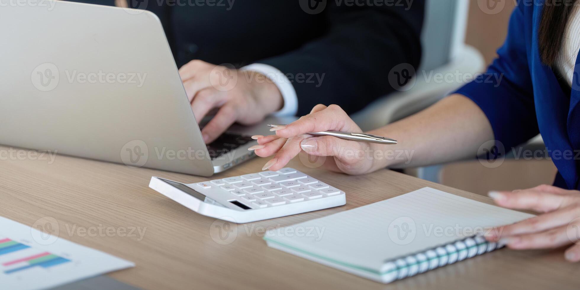 Business professionals analyzing financial data with a calculator and laptop during a meeting. photo
