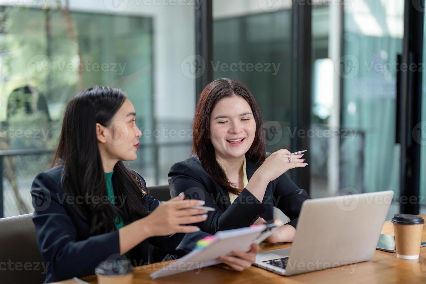 Colleagues discussing financial strategies with documents and a laptop in a collaborative environment. photo