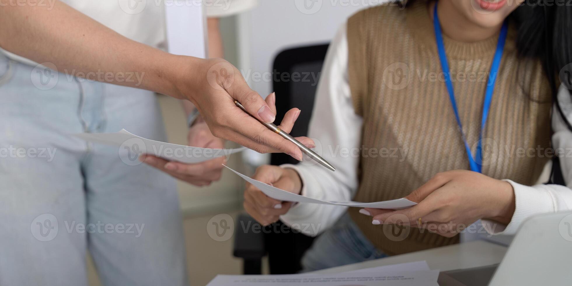 Colleagues exchanging documents and discussing financial reports in a collaborative environment. photo