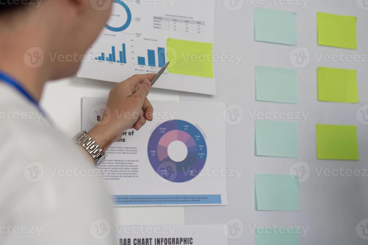 Financial analyst presenting data insights on a whiteboard during a team meeting. photo
