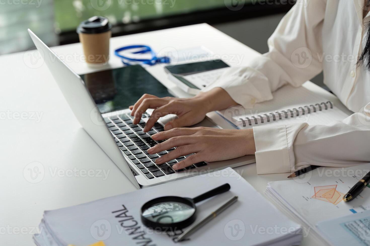 Professional preparing financial documents and analyzing data on a laptop. photo