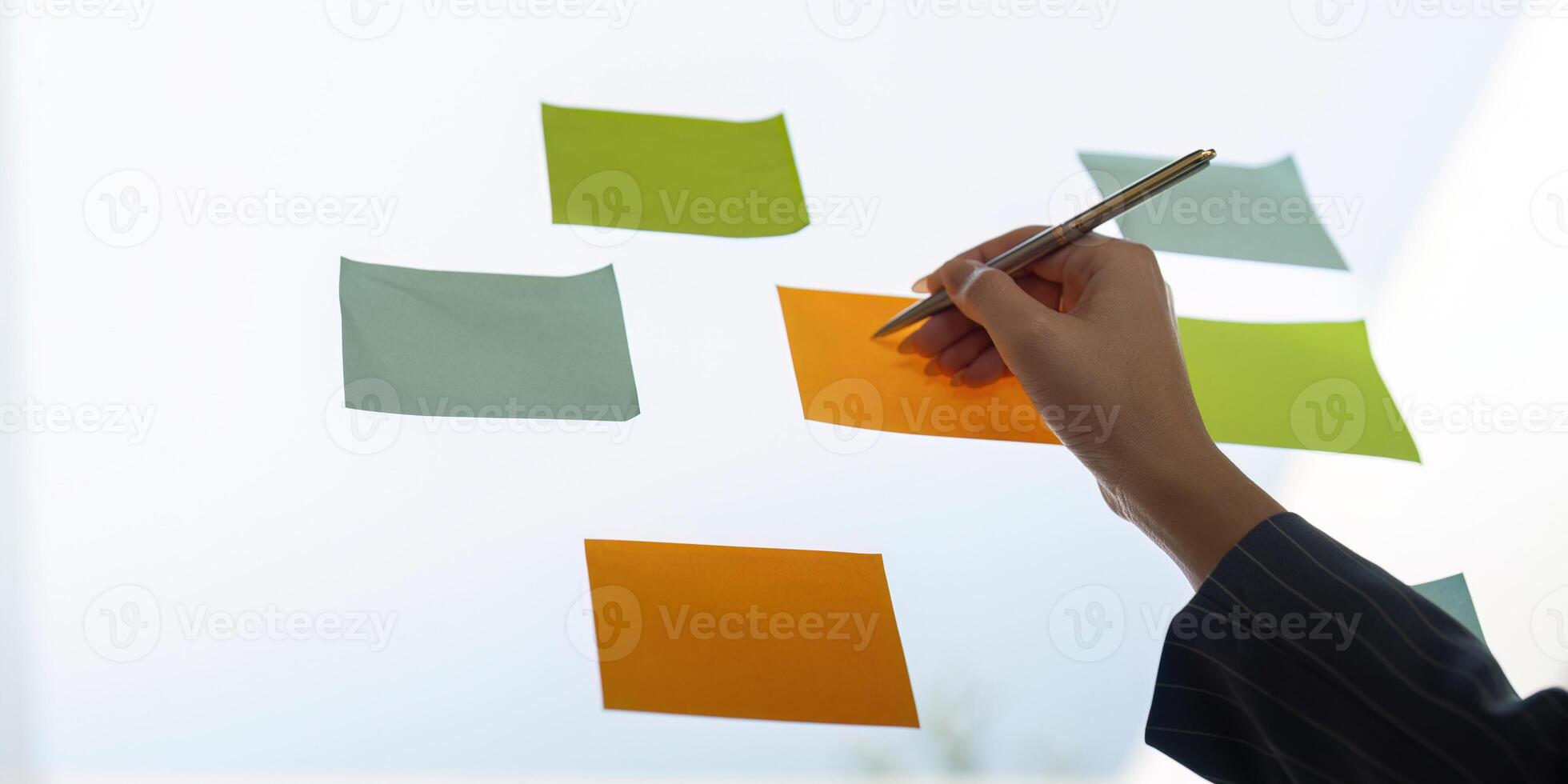 Colleagues sharing insights while arranging sticky notes for project planning and analysis. photo