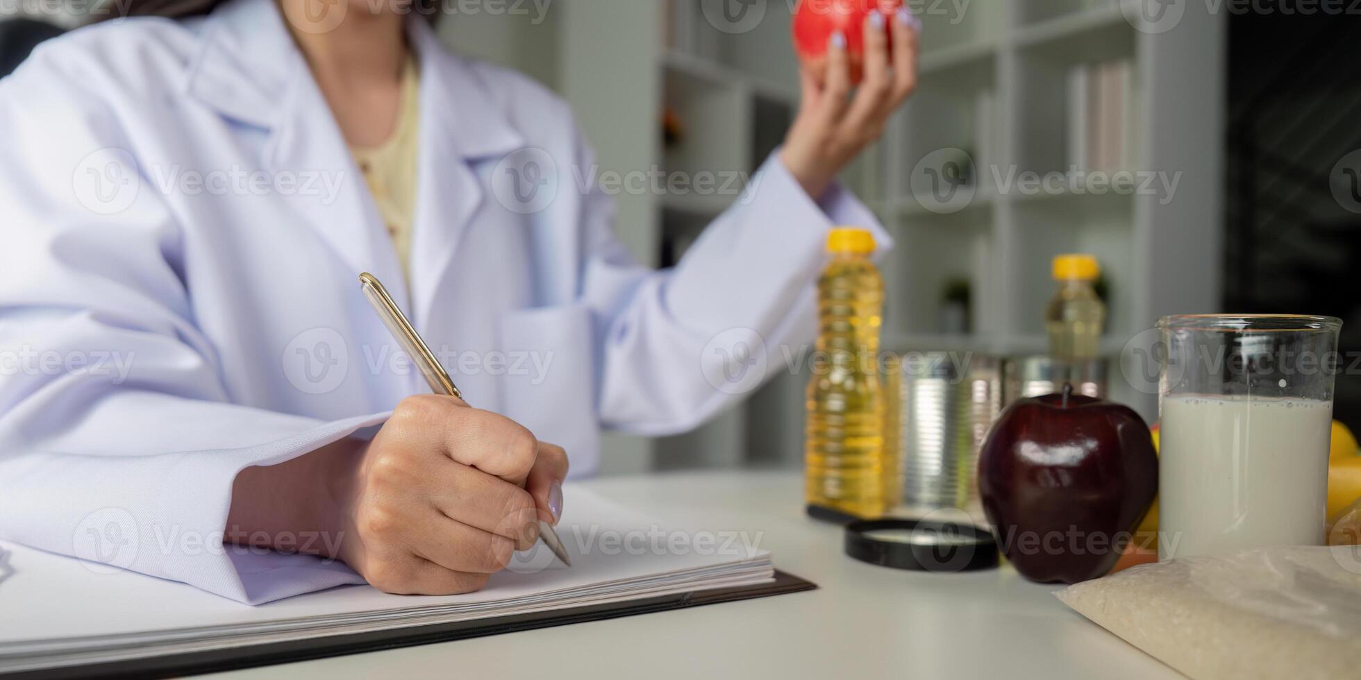 Nutritionist analyzing food options with apple and notebook photo