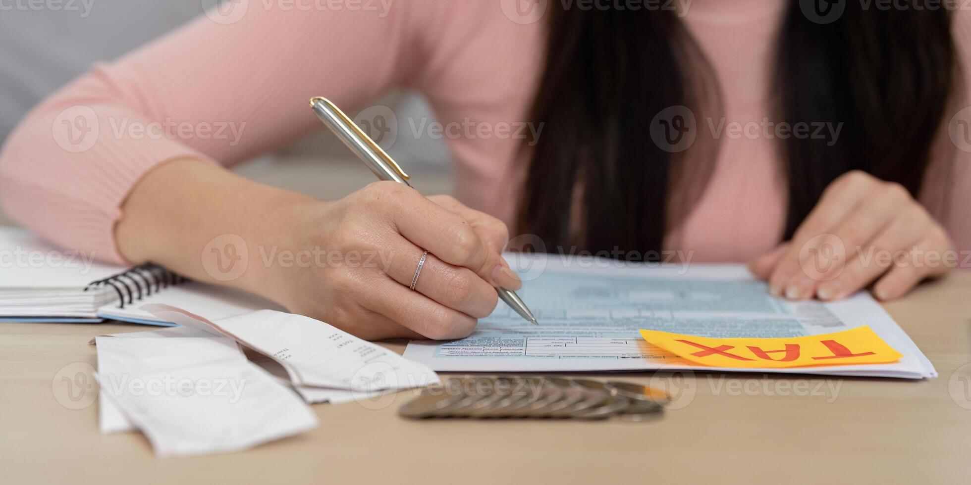 Woman completing tax forms with pen and calculator, highlighting financial strategy and planning. photo