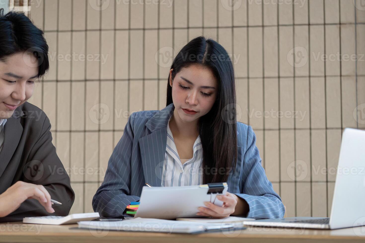Focused accountant reviewing financial documents and collaborating with a colleague in a professional environment. photo