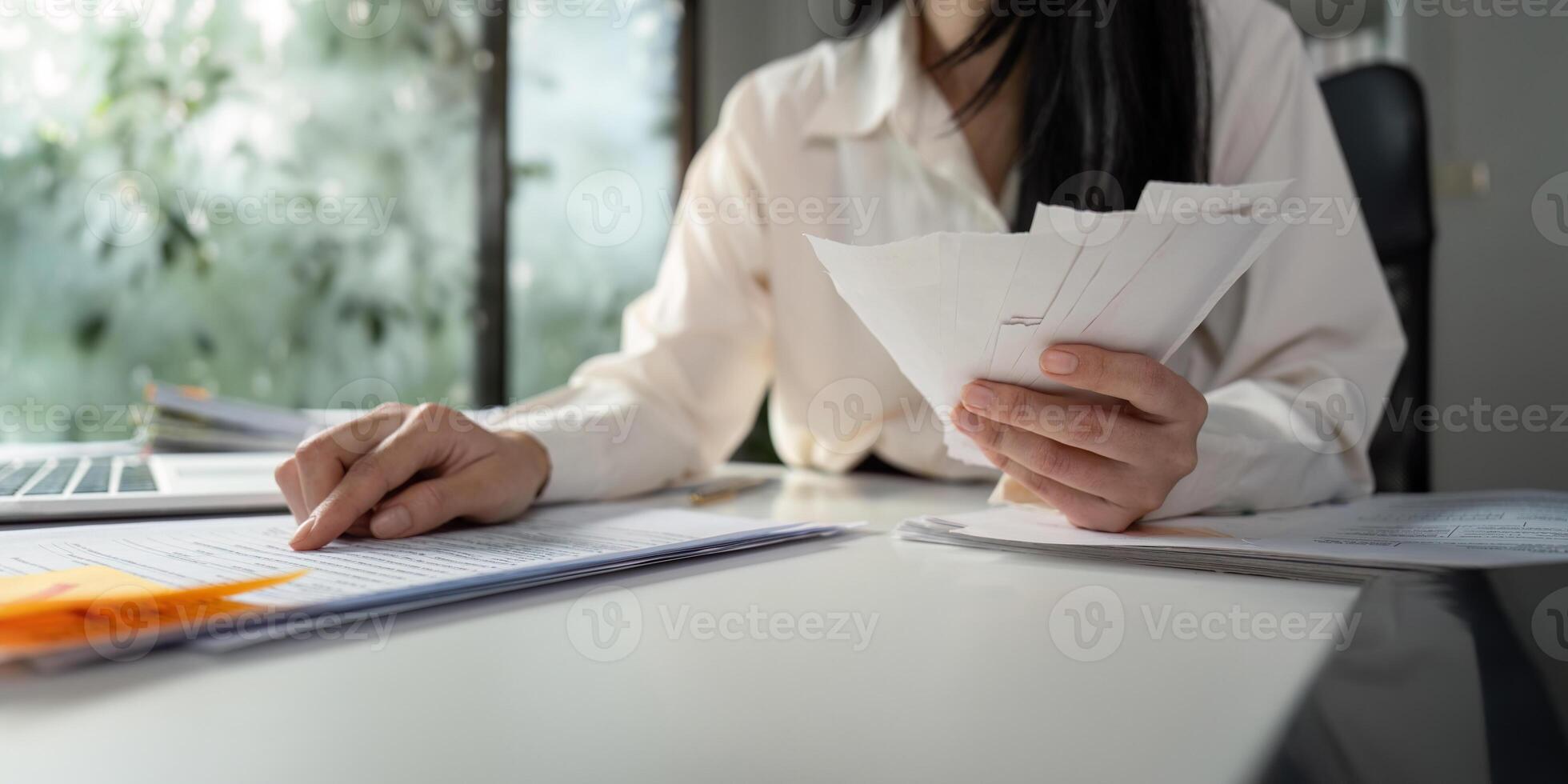 Analyzing financial data while sorting through tax paperwork at a desk. photo