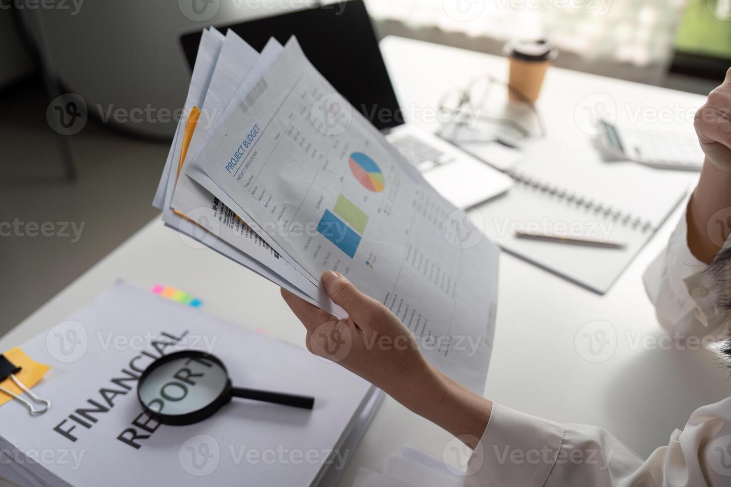 Individual reviewing financial reports and data analysis in a modern workspace. photo