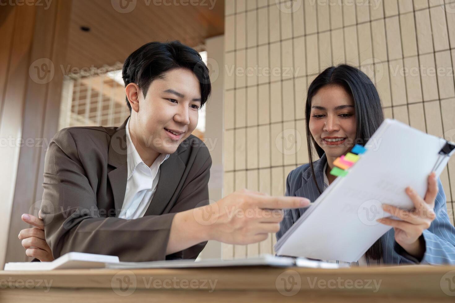Effective teamwork. Two individuals collaborating on project details in a contemporary setting. photo