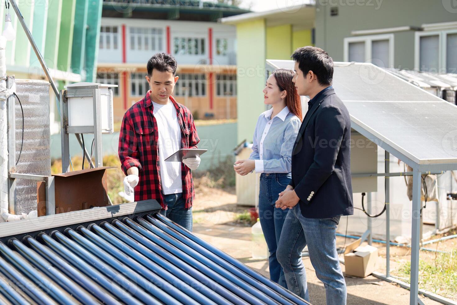 Sustainable energy solutions. A team discusses solar technology implementation while inspecting solar panels and systems outdoors. photo