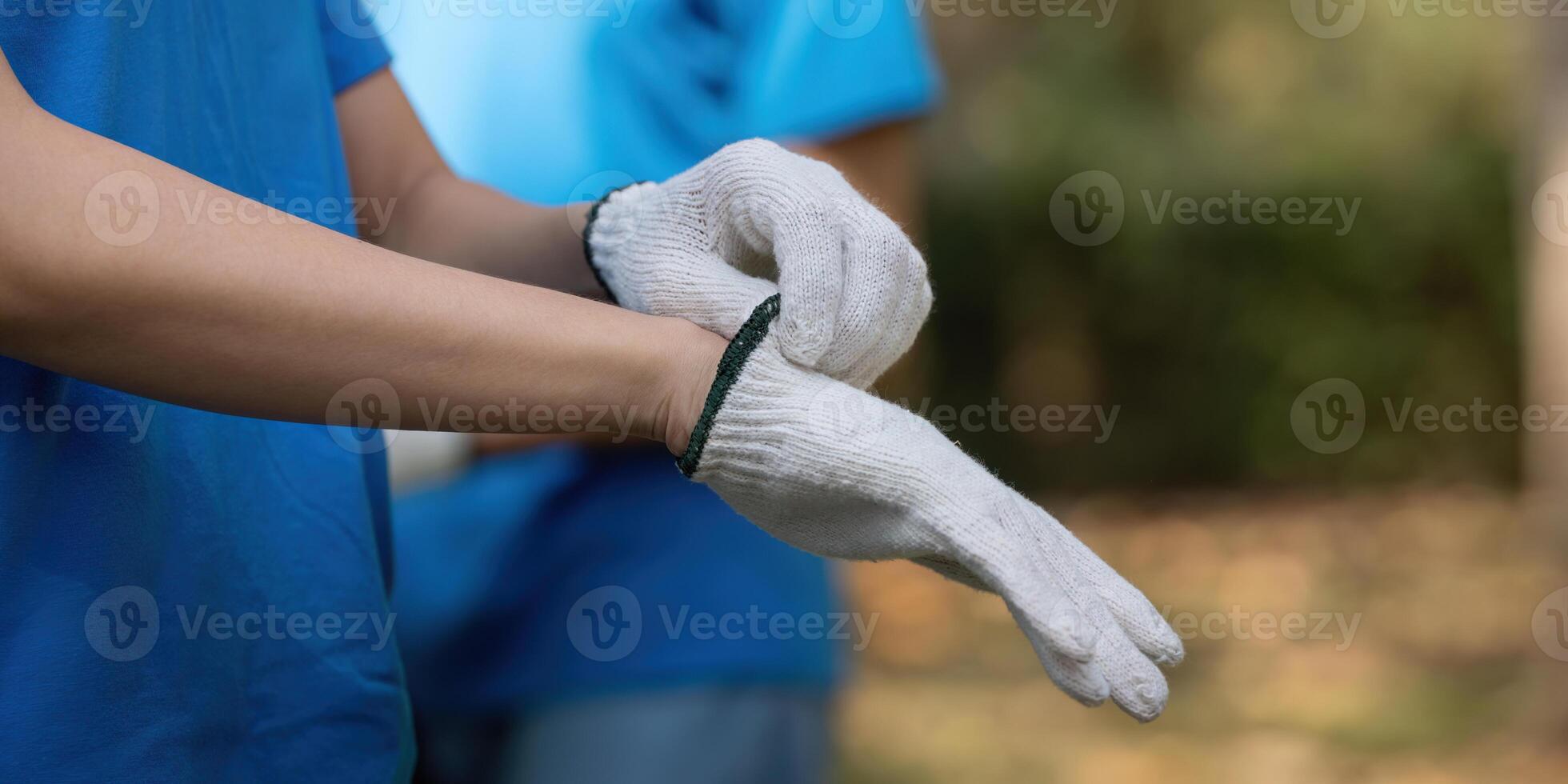 Volunteer preparing to clean up the environment by putting on gloves photo