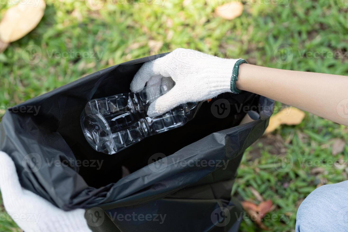 Volunteer collecting plastic bottles during an environmental cleanup initiative. photo