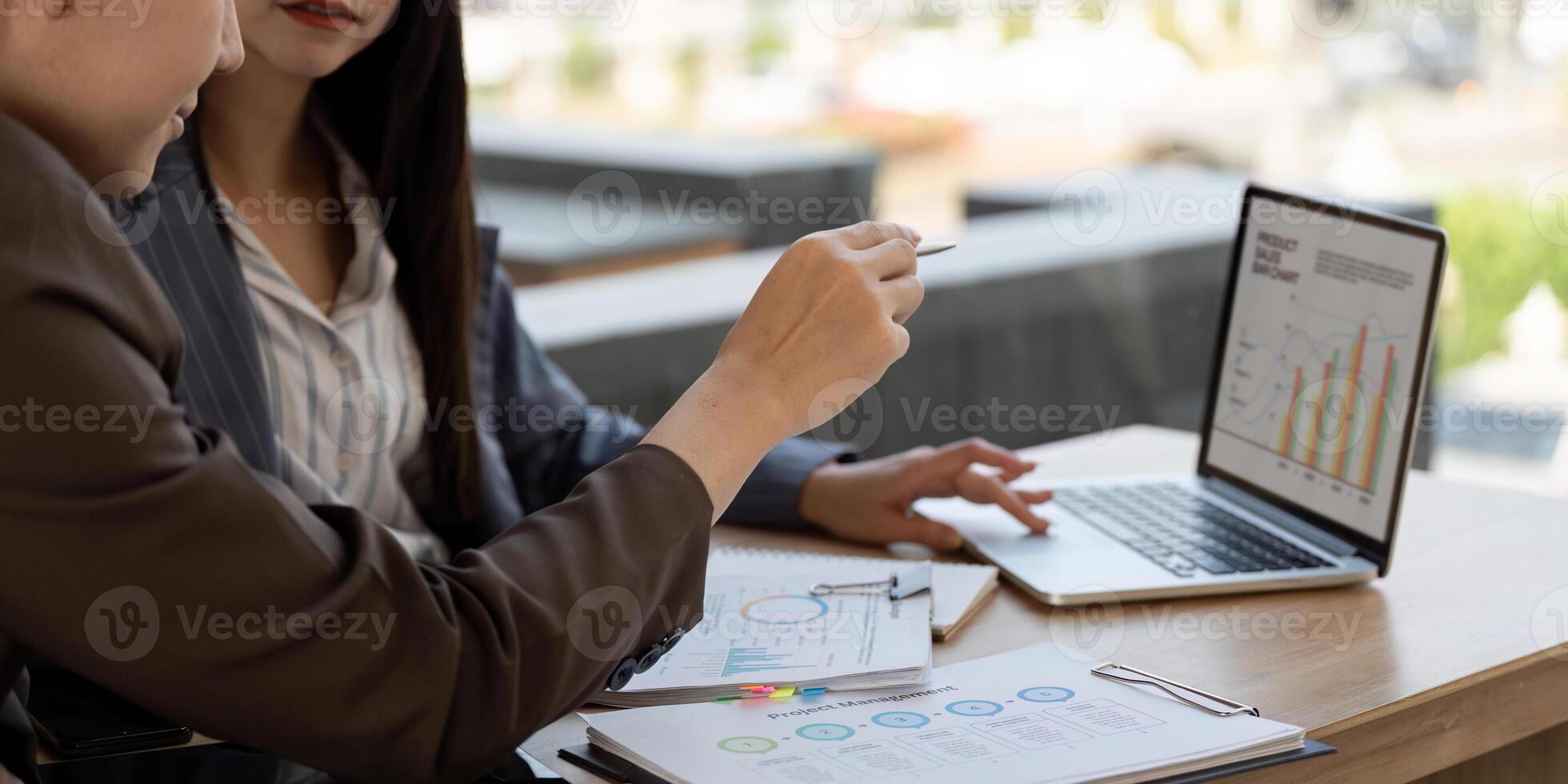 Visual presentation. Two professionals reviewing data and insights on a laptop. photo