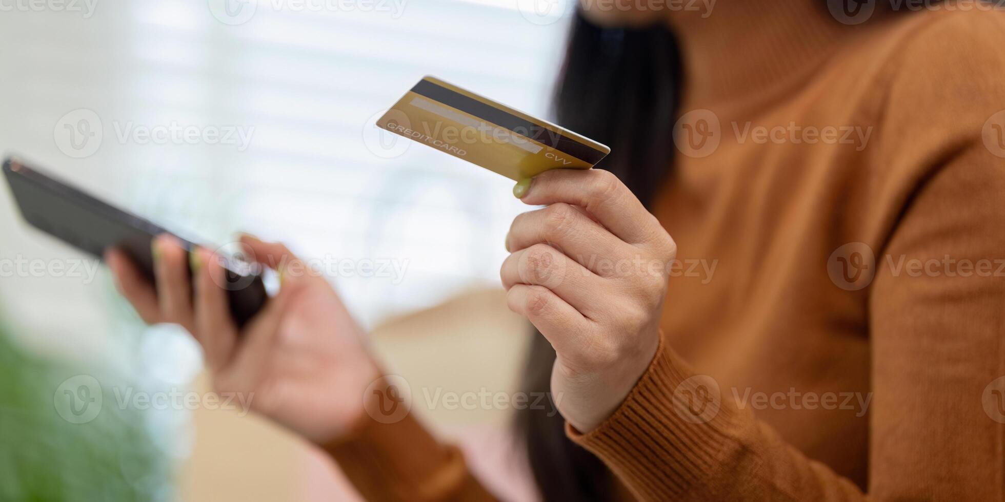 Payment process. Close-up of woman holding credit card and smartphone while shopping online. photo