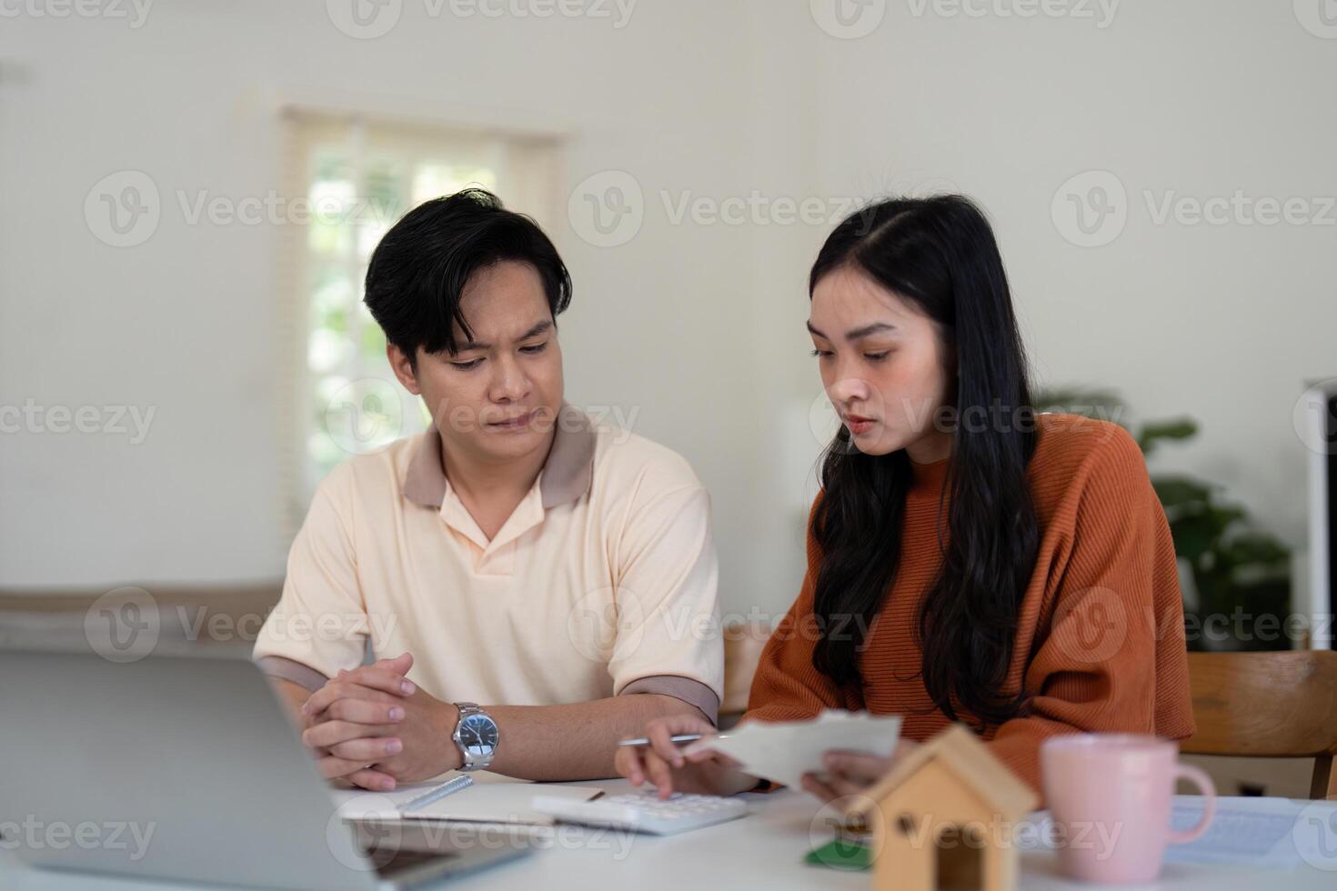 Couples' financial planning. Couple engaged in a serious discussion about their finances at home, showcasing teamwork. photo