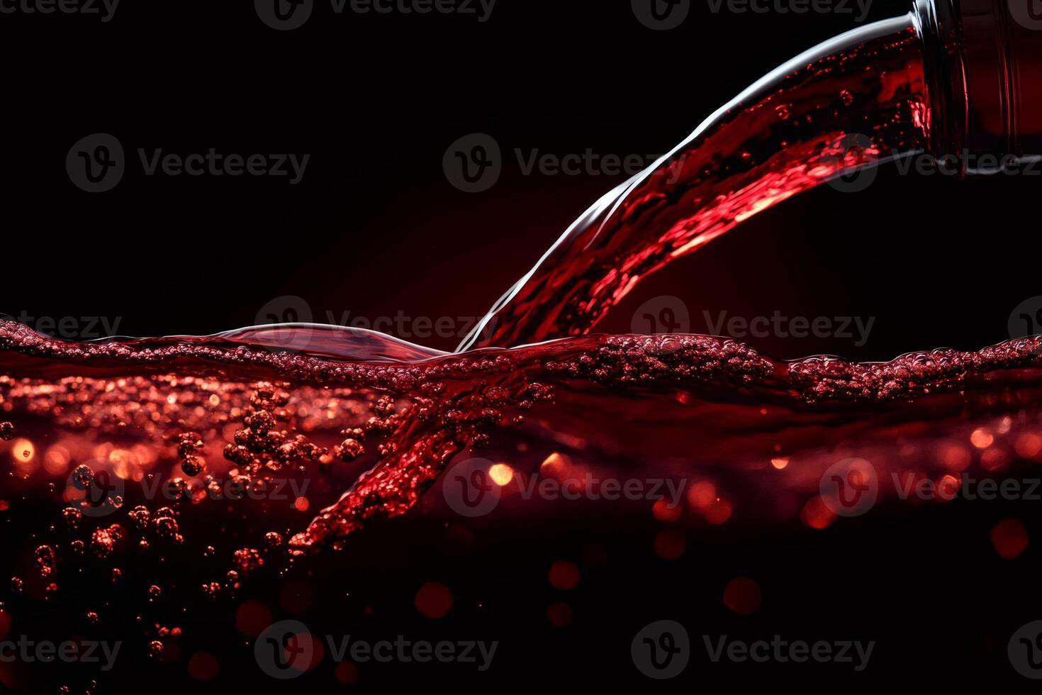 Red wine pouring and splashing into glass with bubbles on black background photo