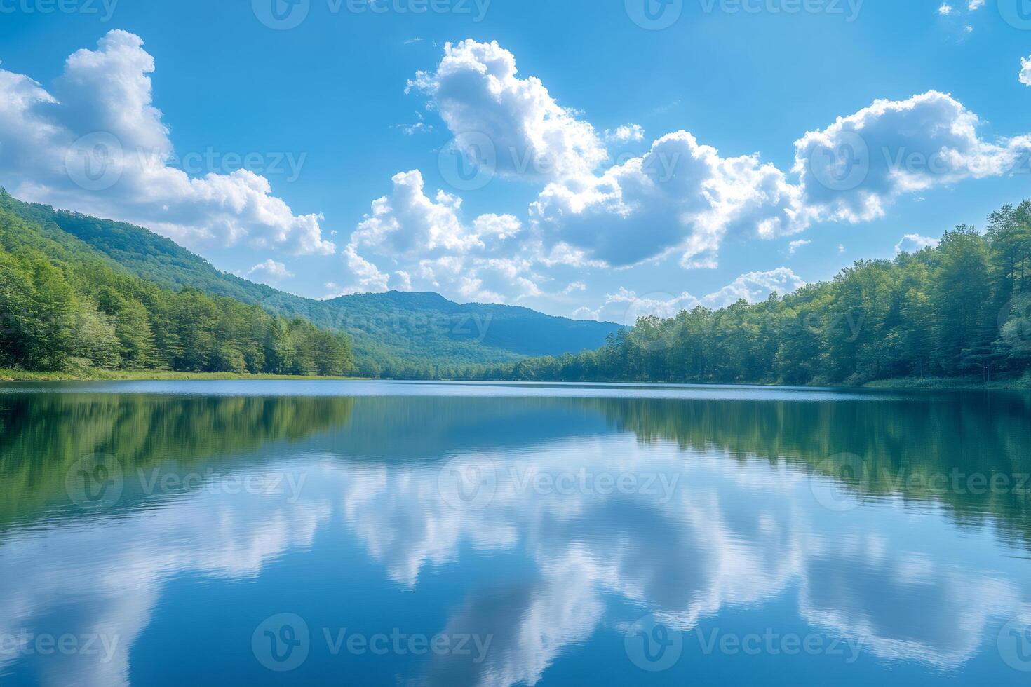 Beautiful lake reflecting clouds and surrounded by green forest photo