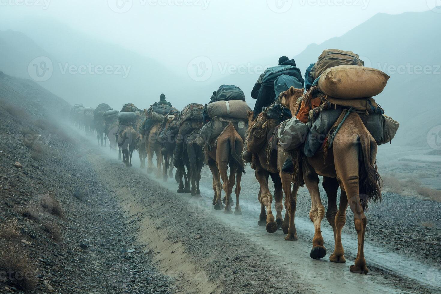 Caravan of Camels Traversing a Misty Mountain Path photo