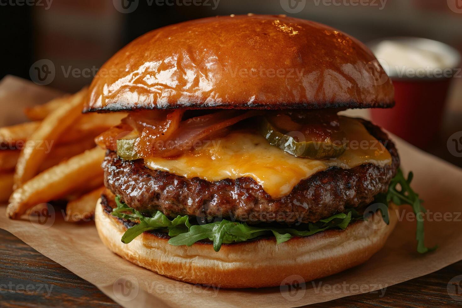 Delicious burger with melted cheese, caramelized onions and jalapenos resting on arugula, served with french fries photo