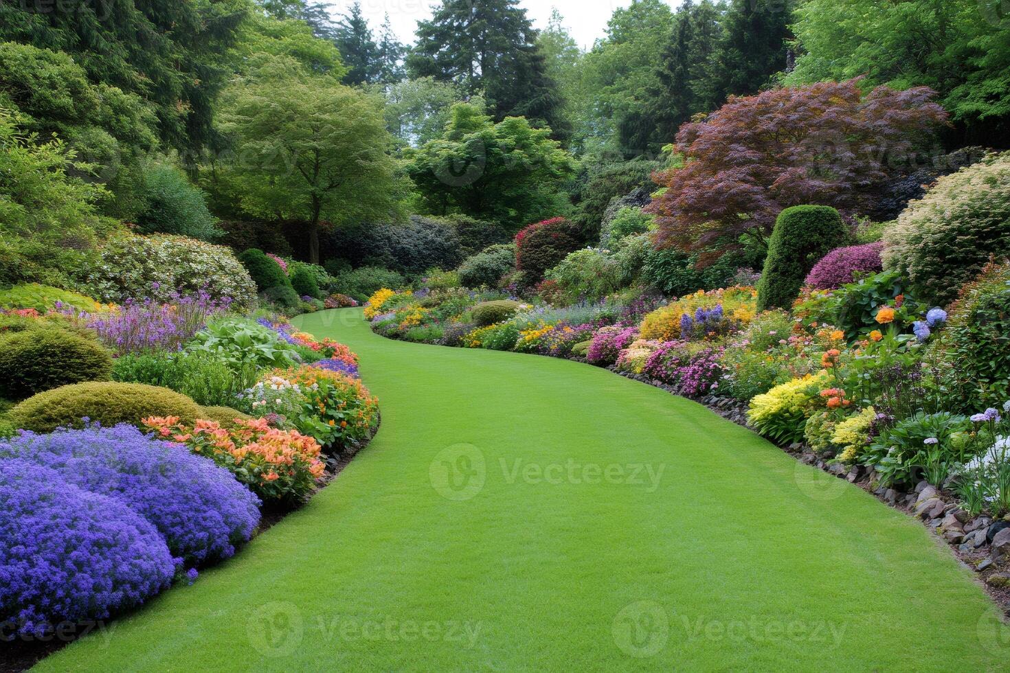 Lush green manicured lawn winding through vibrant flowerbeds in a colorful garden photo