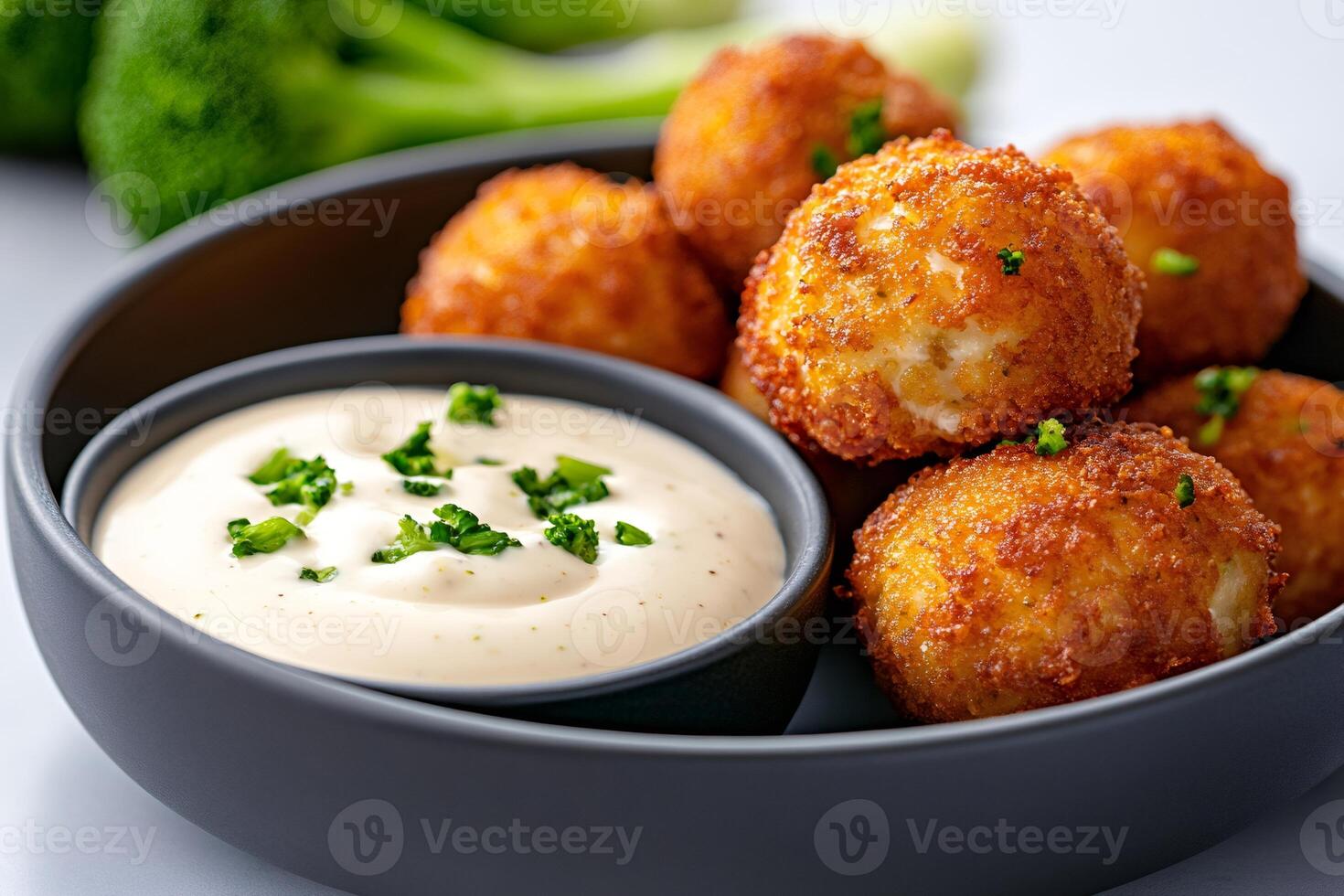 Breaded mozzarella cheese balls with dipping sauce and broccoli florets photo