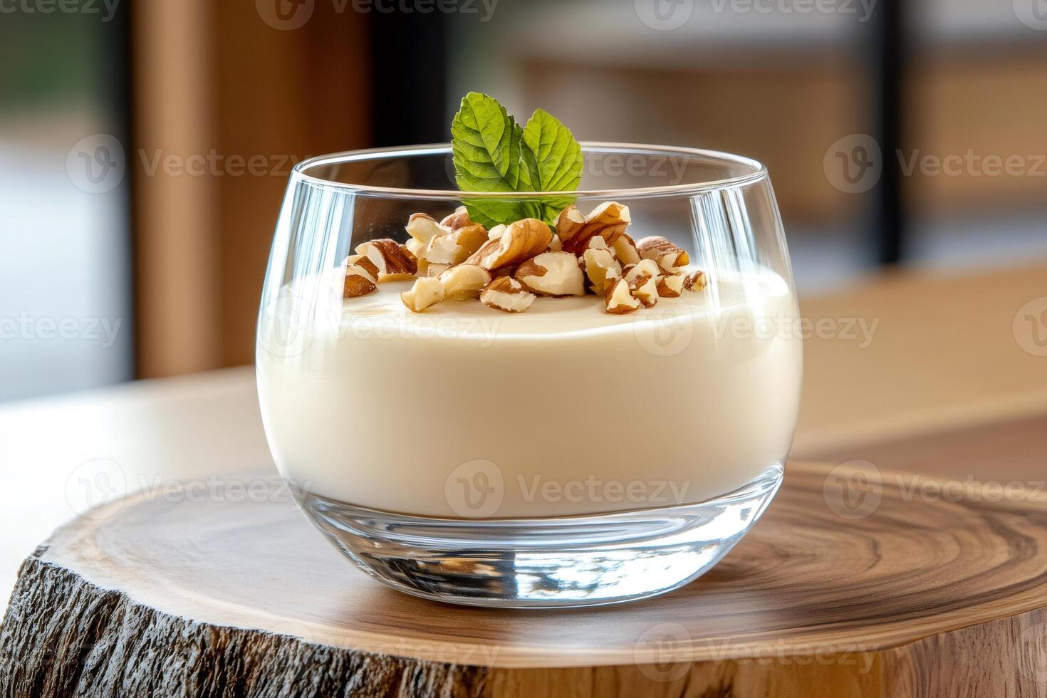 Delicious creamy dessert with pecan nuts and mint leaves served in elegant glass bowl photo
