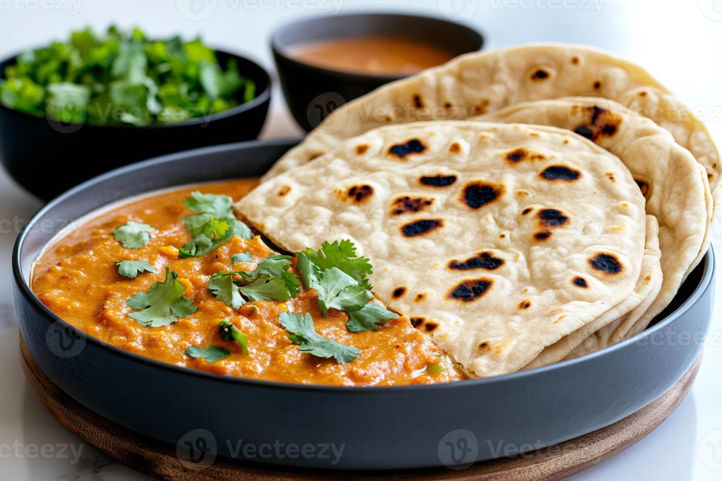 Delicious indian lentil curry with roti flatbread and coriander garnish photo