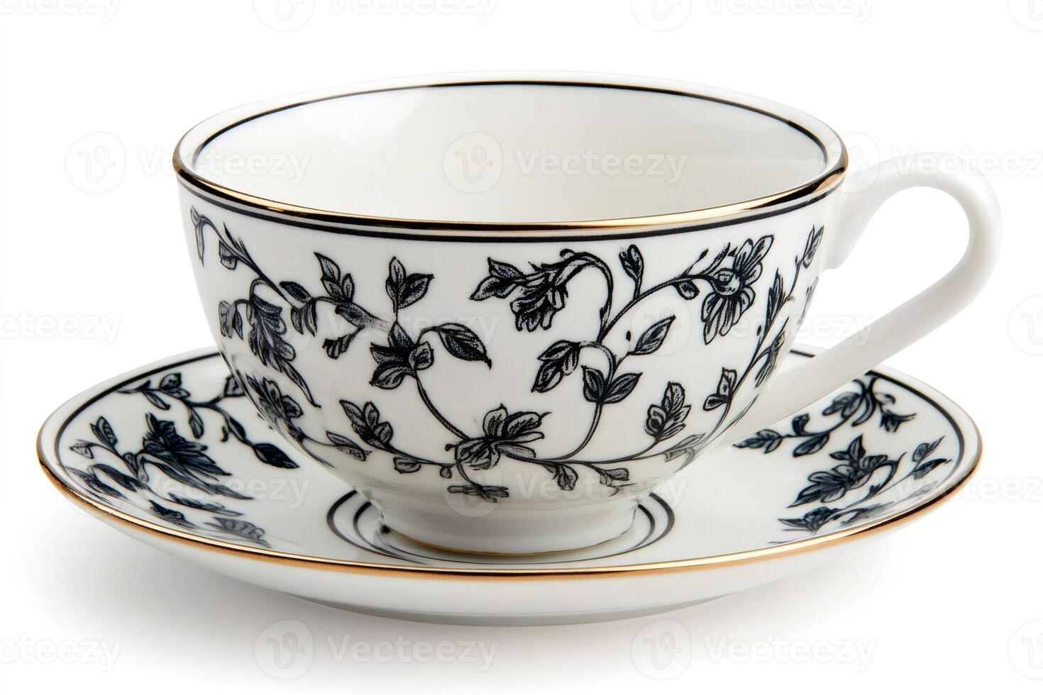 Empty teacup and saucer with black floral design and golden rim resting on white background photo