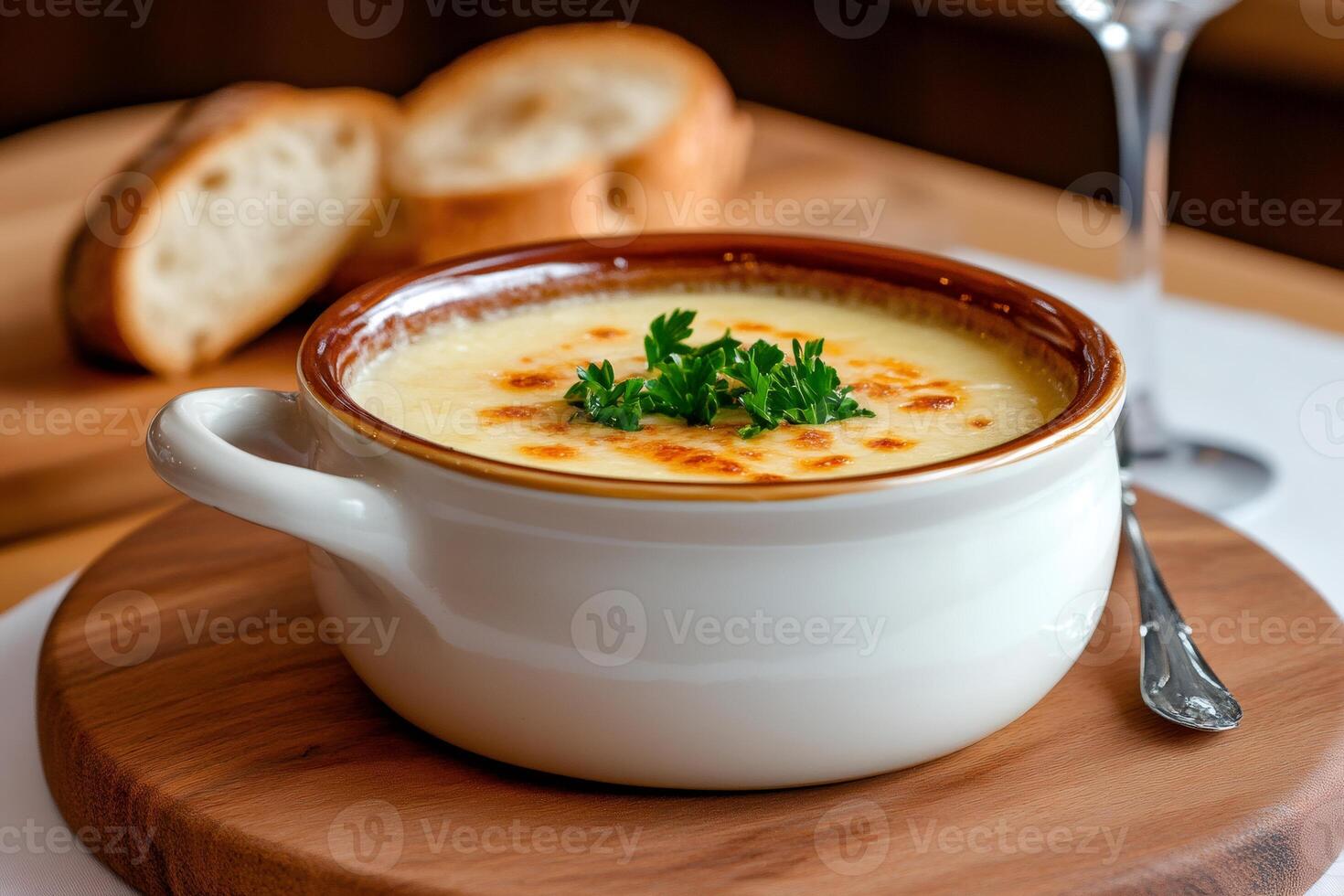French onion soup with toasted bread and wine glass on wooden board photo