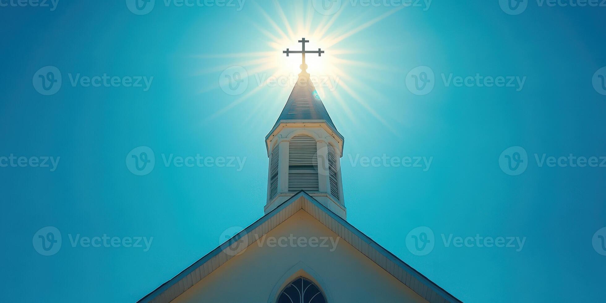 Bright sunlight shines behind church steeple, creating a halo effect at noon on a clear day photo