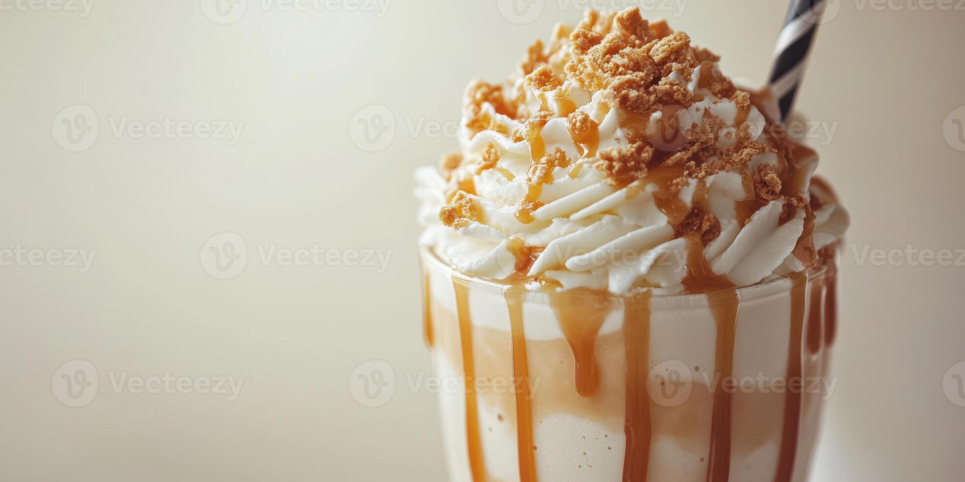 Delicious dessert drink featuring whipped cream and caramel topped with crumbled cookies in a glass with a straw photo