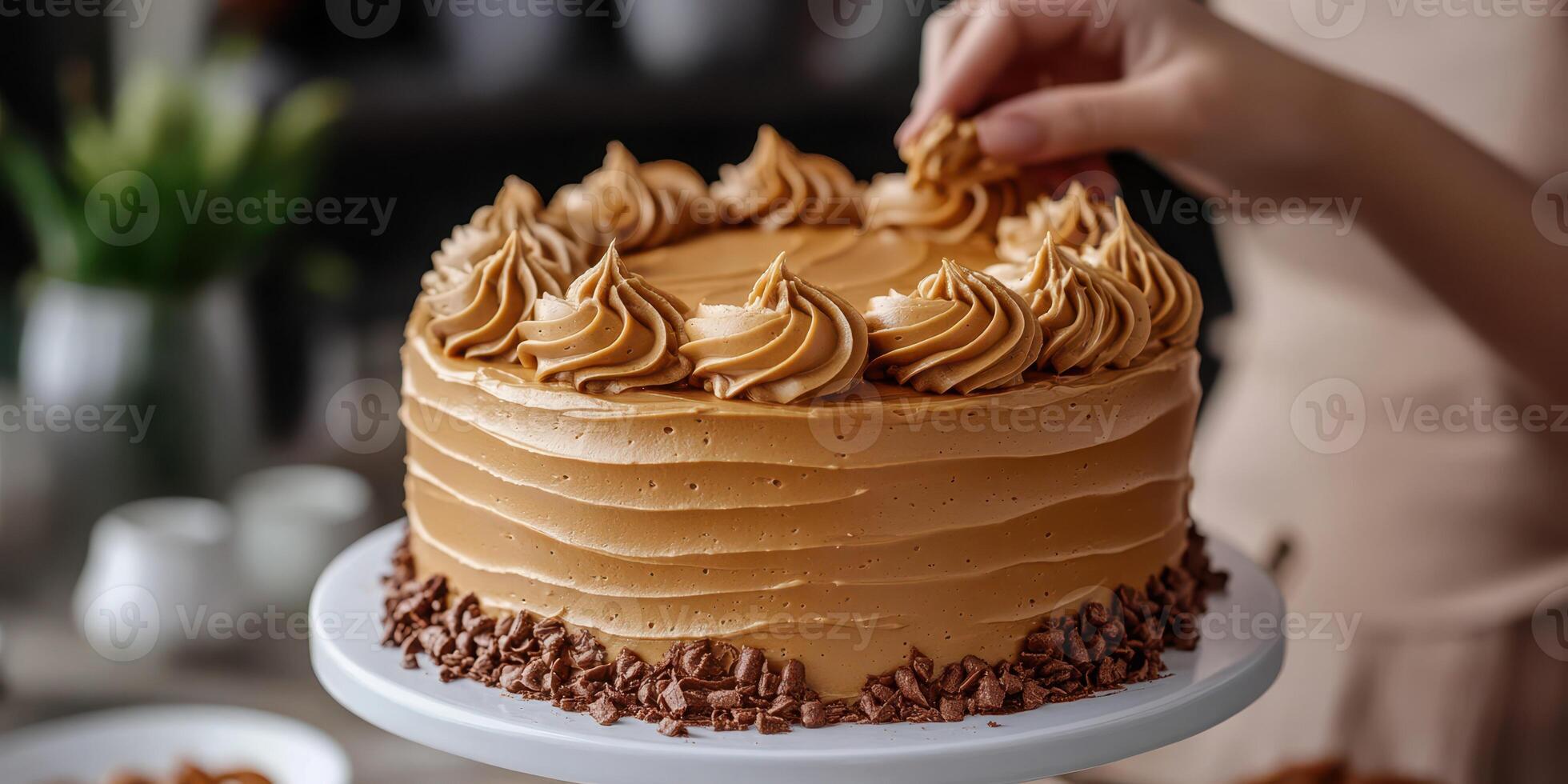 Baker decorates a creamy chocolate cake with swirls of frosting in a cozy kitchen photo