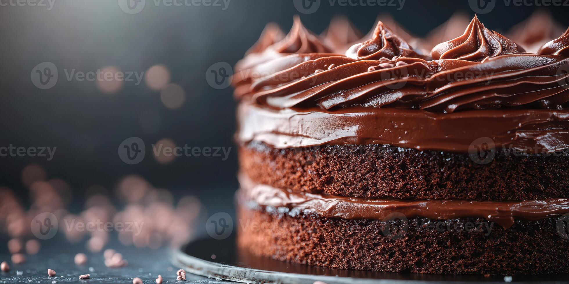 Chocolate cake with rich frosting displayed on a plate with sprinkles scattered around photo