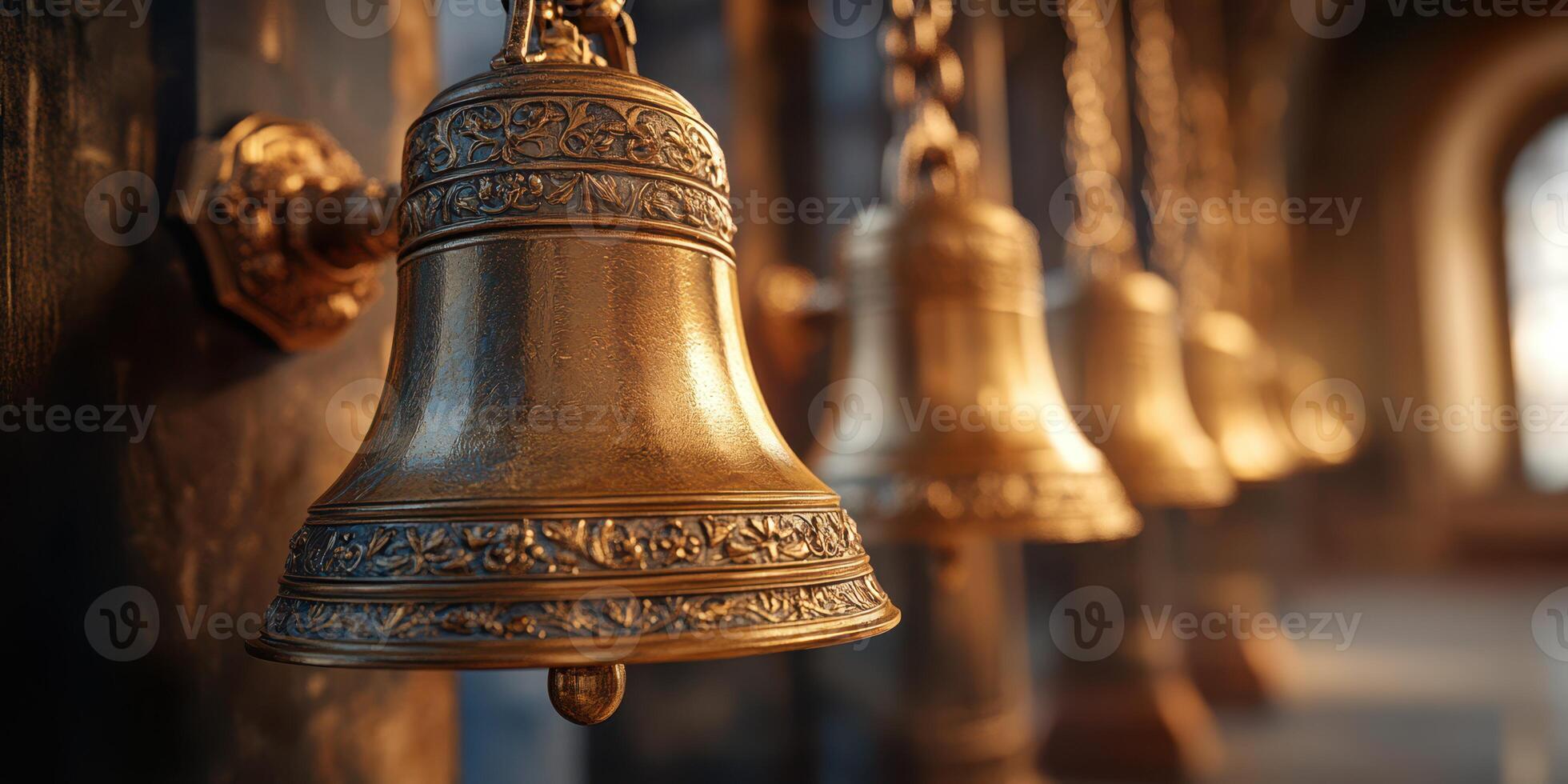 Close view of ornate bronze bells hanging in an ancient structure during the early morning light photo