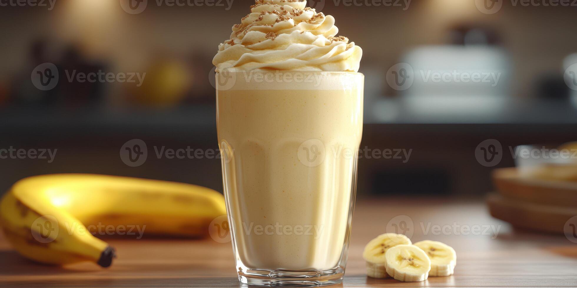 Delicious banana shake topped with whipped cream served in a clear glass on a kitchen counter photo
