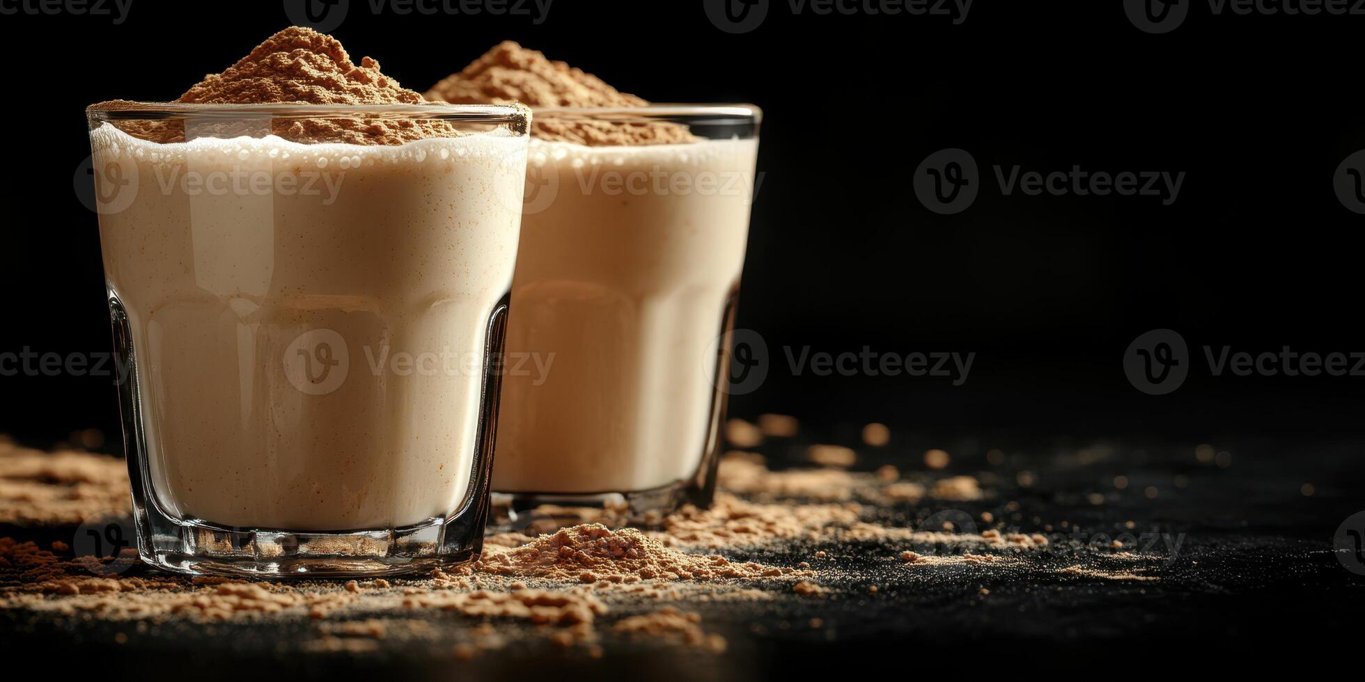 Creamy beverages served in clear glasses with a dusting of cocoa powder in a dark setting photo