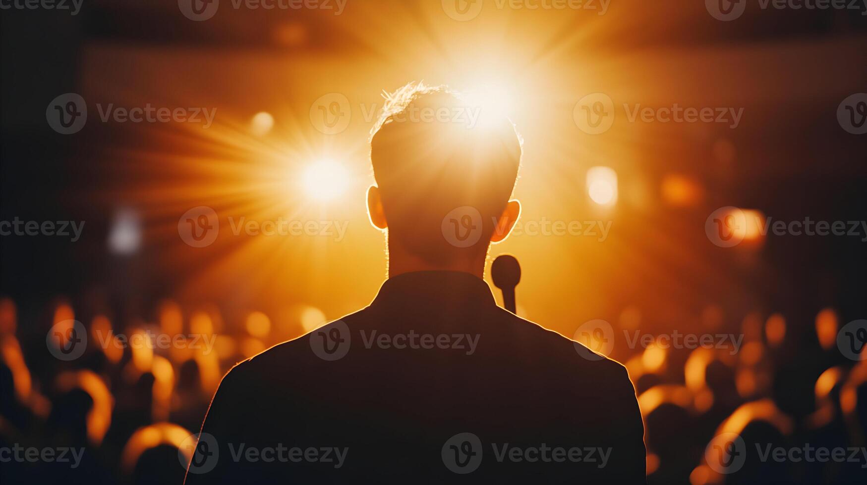 Motivational Speaker Delivering a Speech to a Crowd Under a Spotlight at Conference photo