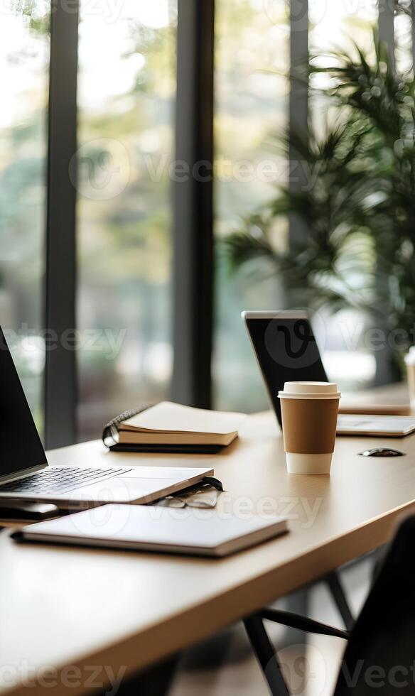 Open workspace environment featuring laptops, stationery, notebooks and coffee cup photo