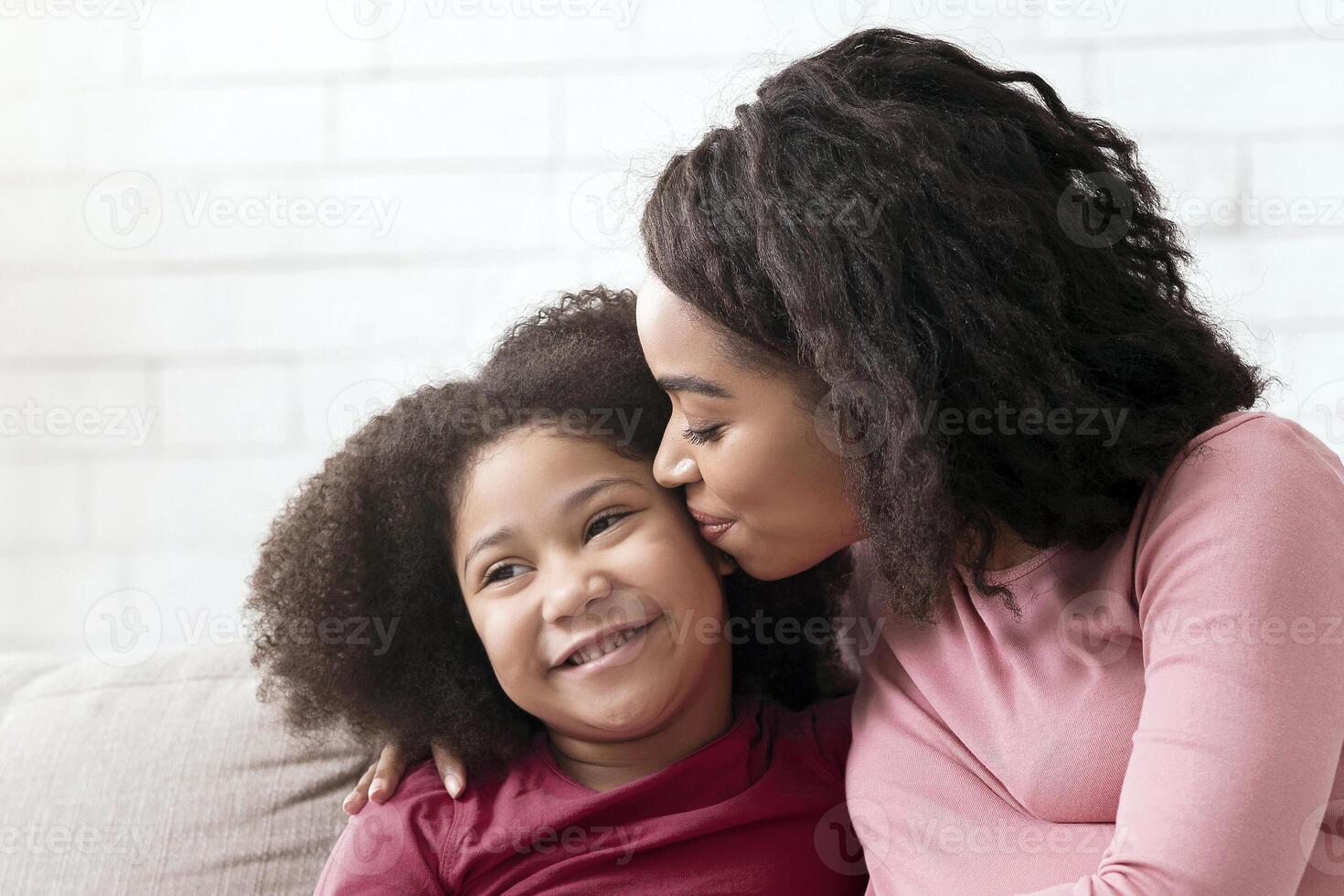 Happy Motherhood. Loving Pregnant Black Mom Kissing Her Little Daughter At Home, Bonding Together While Relaxing On Couch In Living Room, Free Space photo