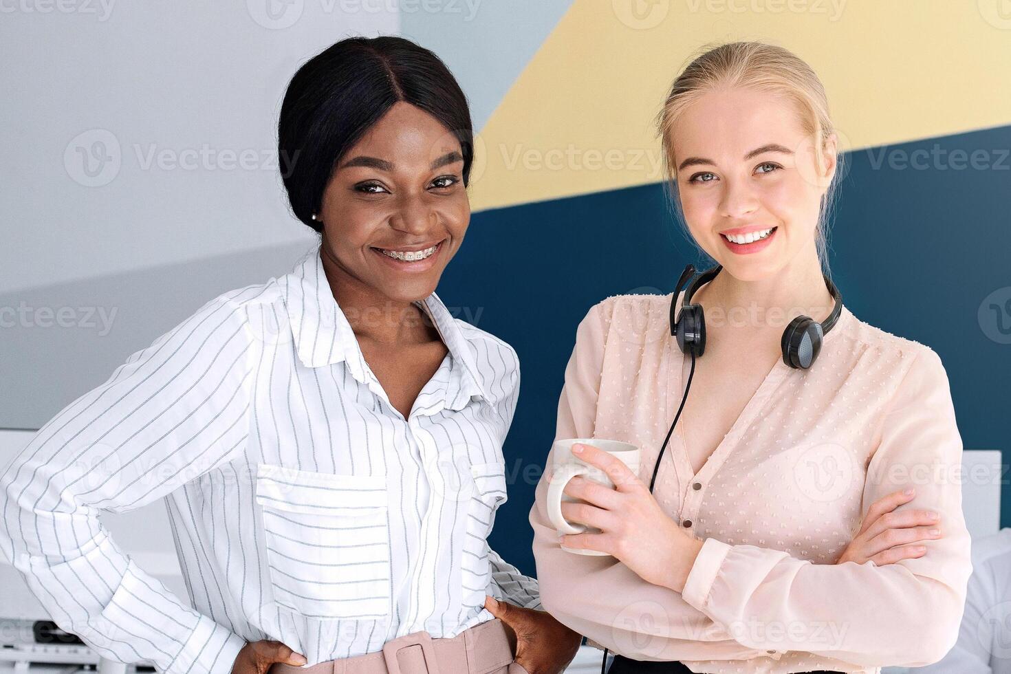 Smiling service desk consultants with their colleagues at modern open space office photo