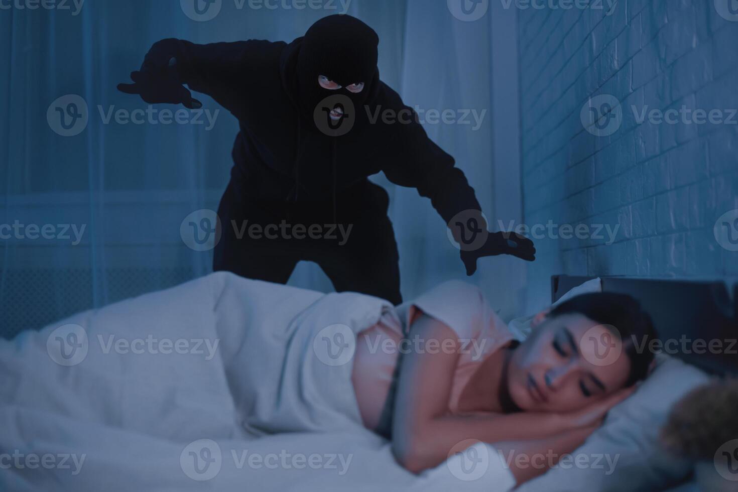 Crime Concept. Masked stalker ready to attack woman who is sleeping in bed at home in the middle of the night photo