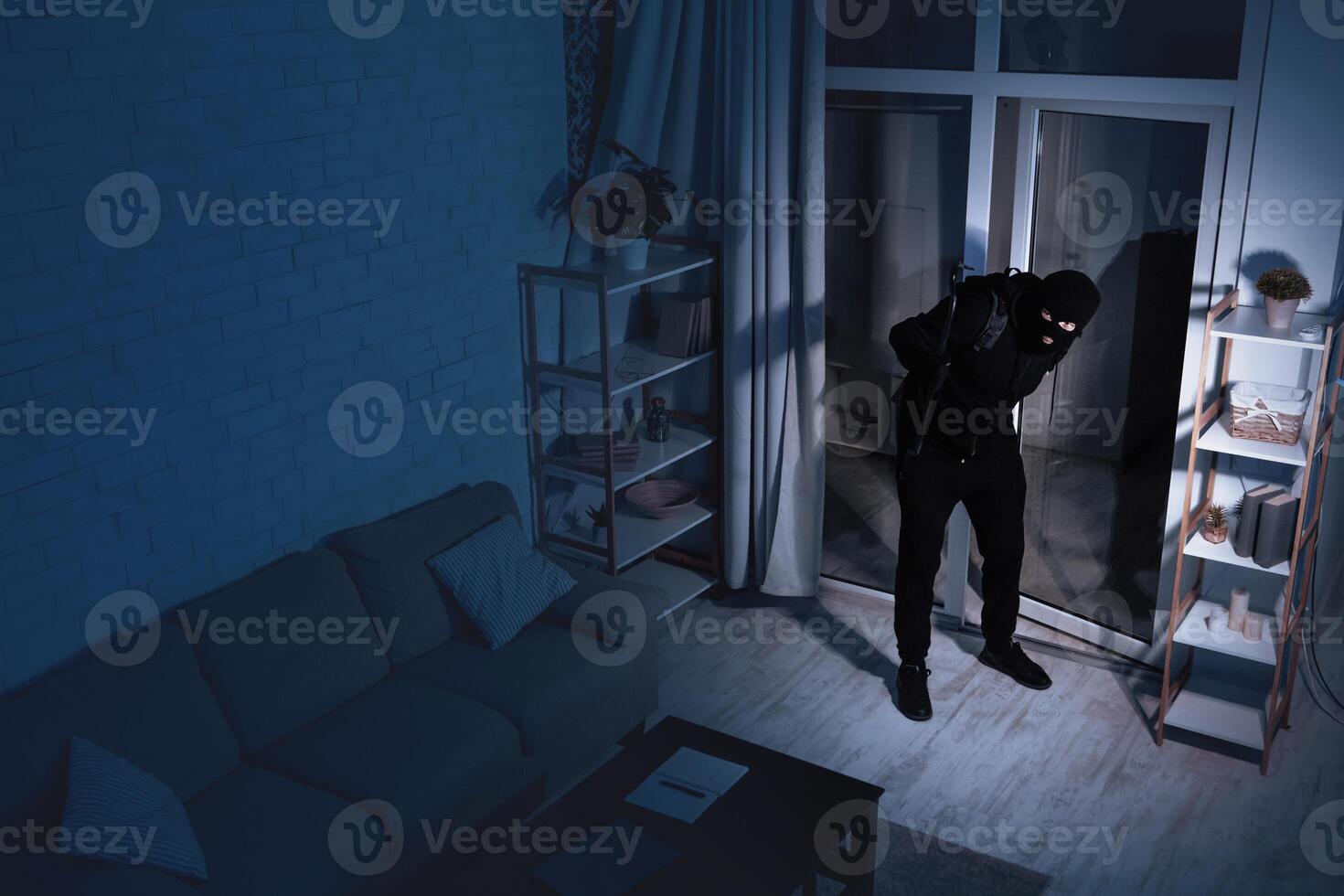 Housebreaking Concept. Intruder sneaking into house at night, holding crowbar, top view from above camera, high angle photo