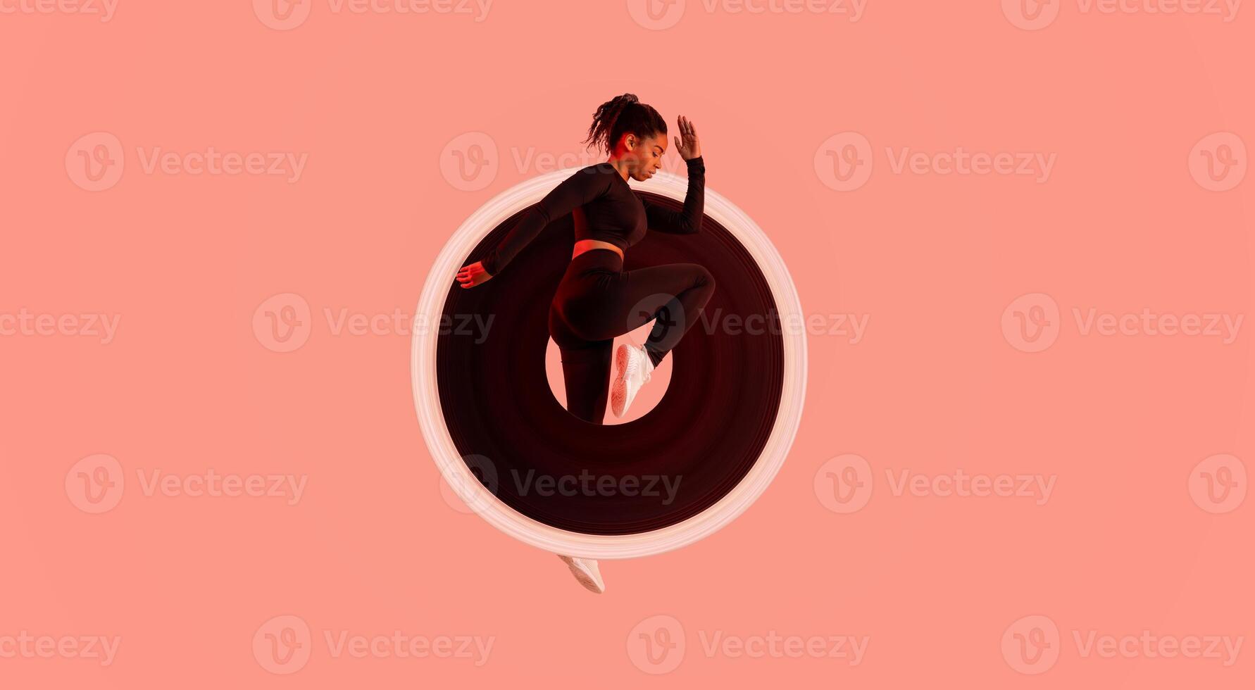 Dynamic moves. Determined African American lady exercising, doing elbow to knee crunches or jumping on red neon studio background, full length, side view photo
