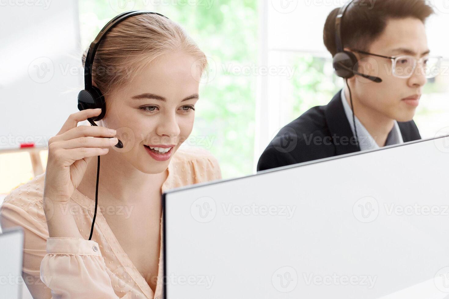 Group of millennial operators with headsets working at call centre photo